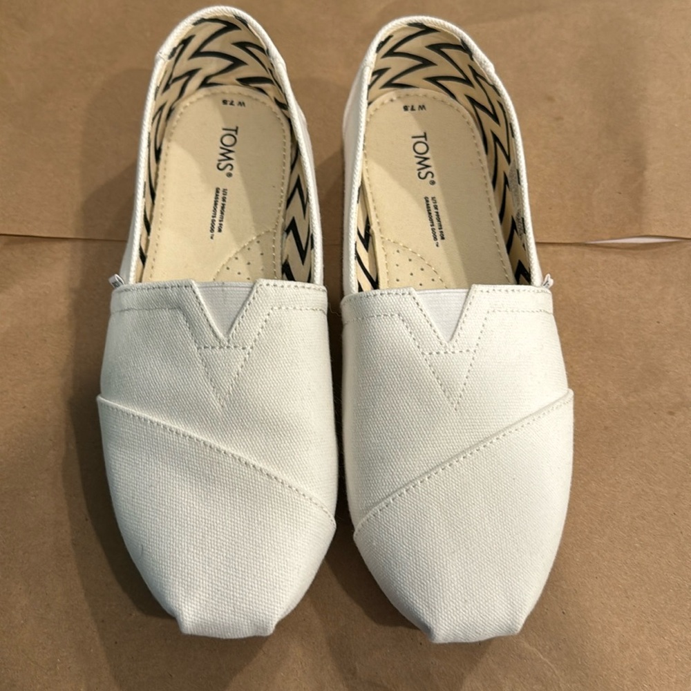 TOM’s white canvas shoes. Never worn. Kept in smoke free and pet free home.